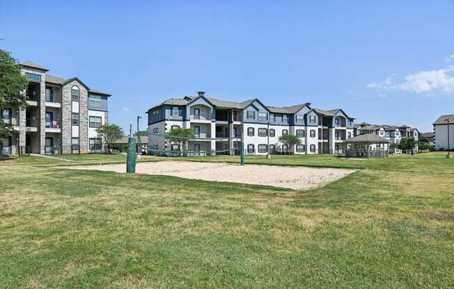 an open field with an apartment building in the background