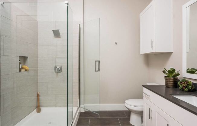 spacious bathroom with glass framed shower doors at Tinsley on the Park apartments