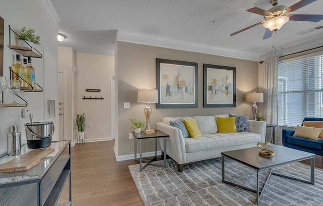 A modern living room with a white sofa and a grey coffee table.