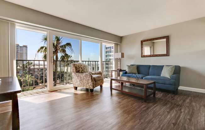 Living room with wood style floors and balcony on the left, large windows with great views