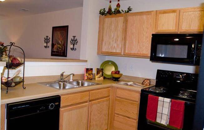 A kitchen with wooden cabinets and a black oven.