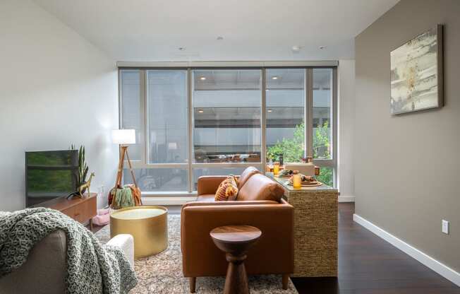 a living room with brown furniture and a large window