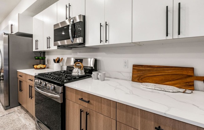 a kitchen with white cabinets and a stove and a microwave