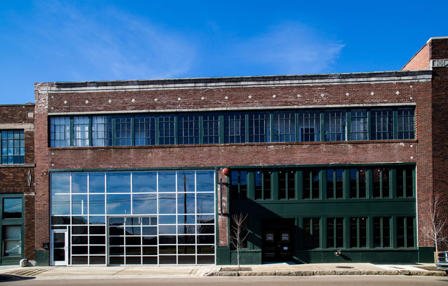 photo of the front of a red brick building with large windows