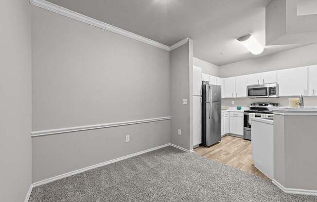 A kitchen with a refrigerator, microwave, and oven.