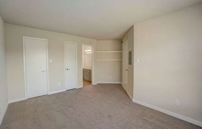 an empty living room with white walls and carpet