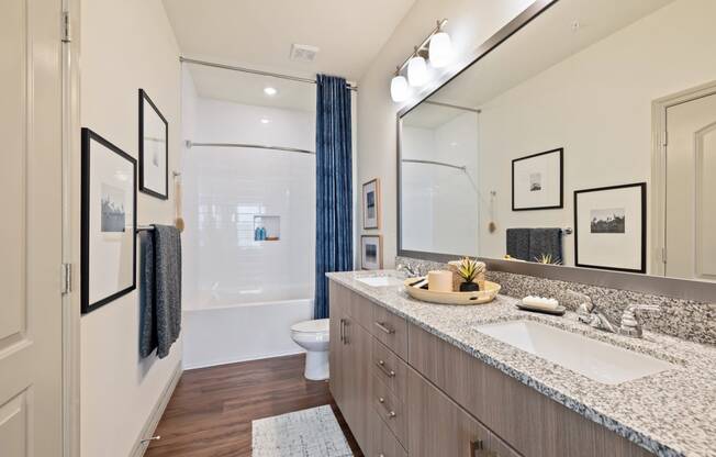 Apartment bathroom with double vanity sinks and custom framed mirror