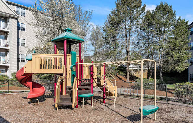 A playground with a red slide at the Ledges Apartments.