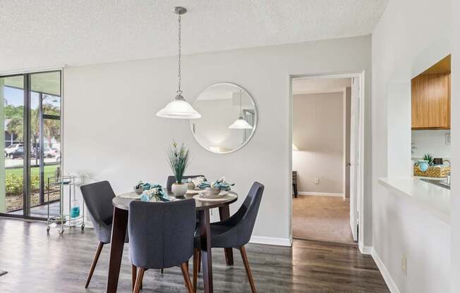 A dining room with a table set for two and a large window.