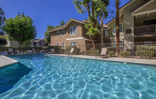 the community pool with green bushes