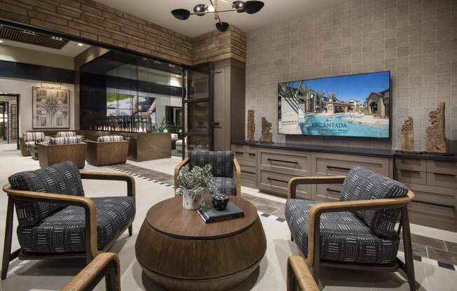 a lobby with chairs and a table and a tv