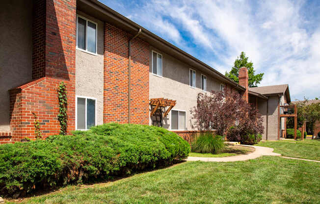 A red brick building with a green lawn in front.