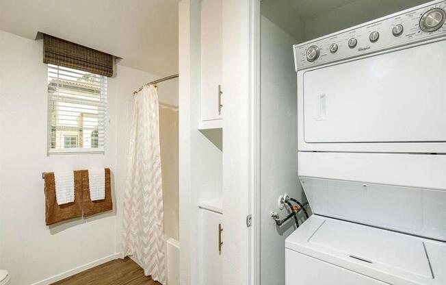 Bathroom comes with two cabinets and on the side washer and dryer with a door
