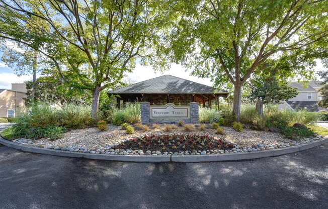 Vineyard Terrace community entrance with monument signage and mature trees on each side. 