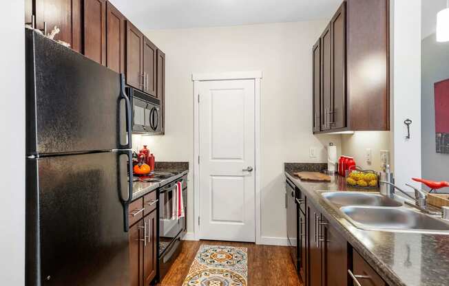 a kitchen with dark wood cabinets and stainless steel appliances at Mullan Reserve Apartments, Missoula, MT 59808