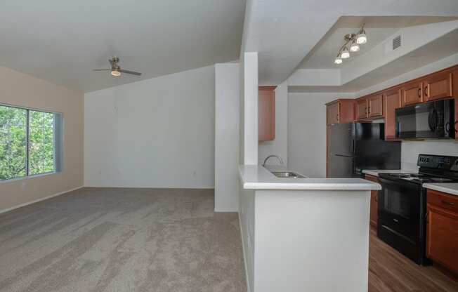 an empty kitchen and living room with a large window