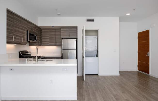 a kitchen with a sink refrigerator and a washer and dryer
