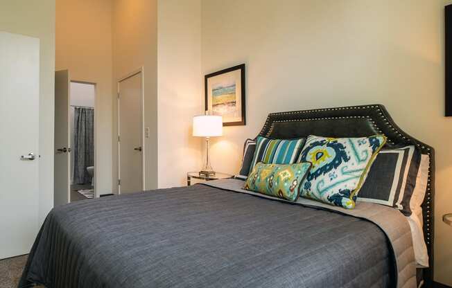 a bedroom with a bed and a door to a bathroom at Link Apartments® Canvas, Atlanta, GA, 30312