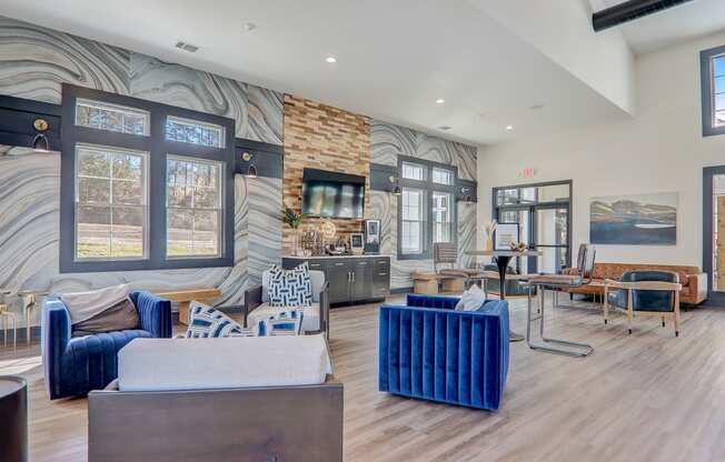 a living room with couches and chairs and a wall mural