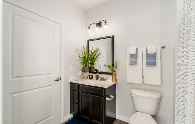 A white toilet sits next to a white sink in a bathroom.