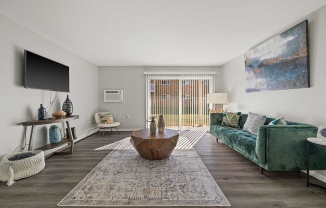 a living room with a green couch and a television