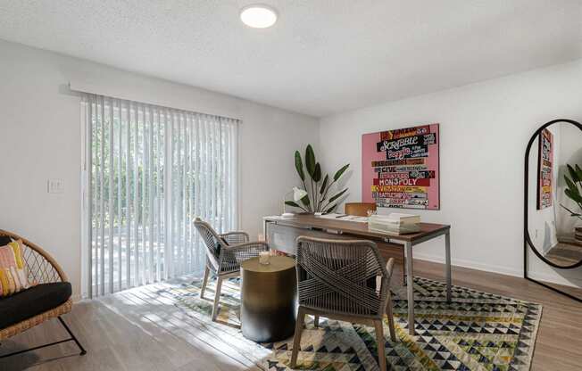 a desk with a chair and a table in a room with a sliding glass door