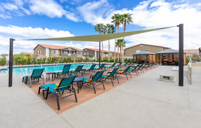 A row of sun loungers are set out on a concrete surface.