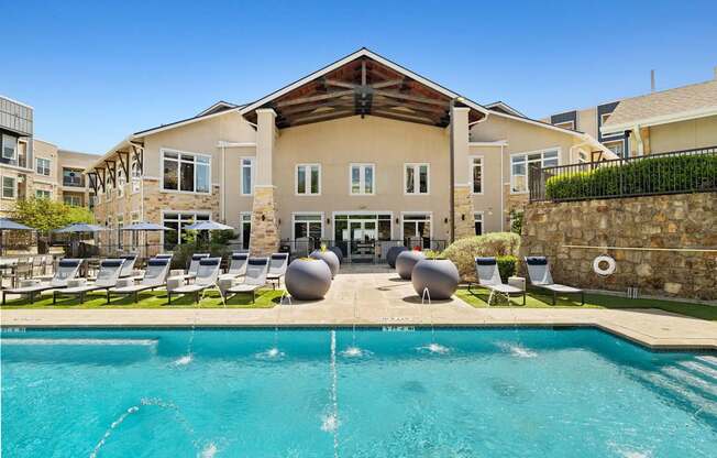 A large building with a pool in front of it.