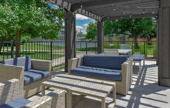 a patio with couches and chairs and a pergola