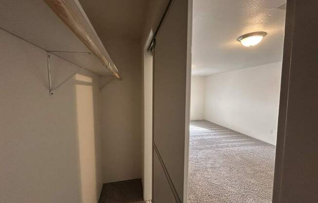 A hallway with a carpeted floor and white walls.