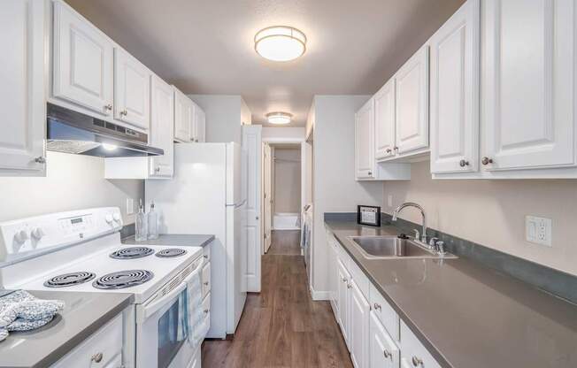 Modern kitchen with white cabinets and stove at Quartz Creek Apartments in Mountlake Terrace, WA