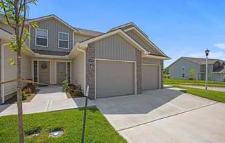 a beige house with a driveway and a garage door