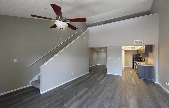 A room with a staircase and a ceiling fan.