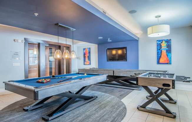 a games room with two pool tables and two foosball tables