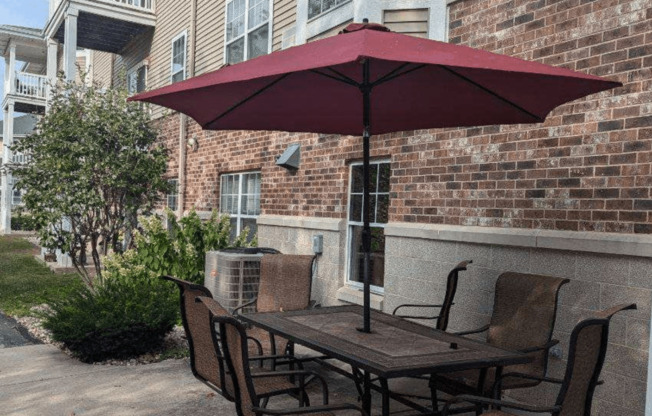 a table with chairs and an umbrella on a patio