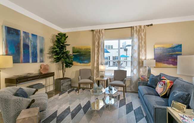 a living room with a blue couch and a glass coffee table at Aster Apartments, Beachwood Ohio