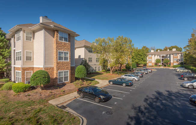 A parking lot in front of a building with cars parked.