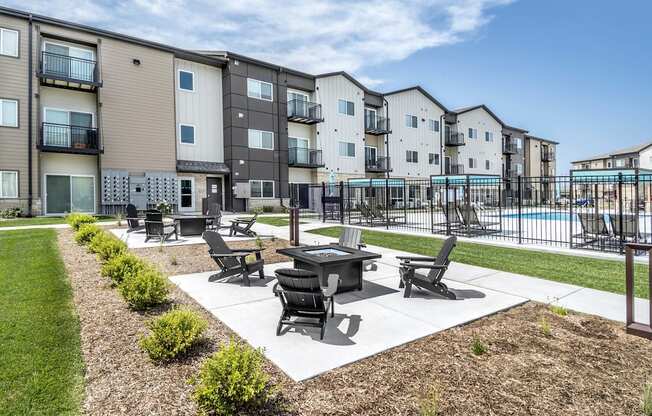 A sunny day at a residential complex with a pool and a patio area.