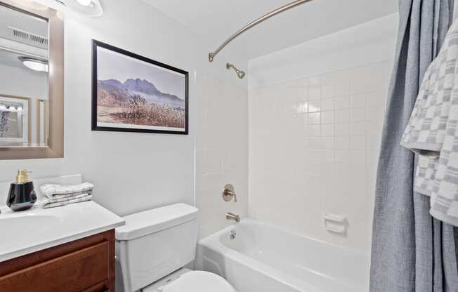 a white bathroom with a tub and a toilet and a sink