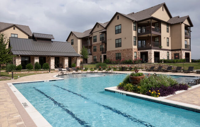 A large swimming pool in front of a multi-story apartment building.