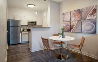 a kitchen with stainless steel appliances and a table with chairs at Volare at the Woodlands, The Woodlands, TX, 77384