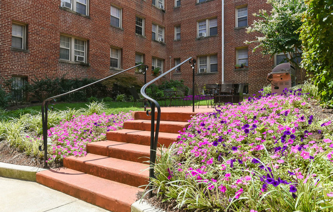 courtyard with table, chairs, grilling area and lush landscaping at meridian park apartments in washington dc