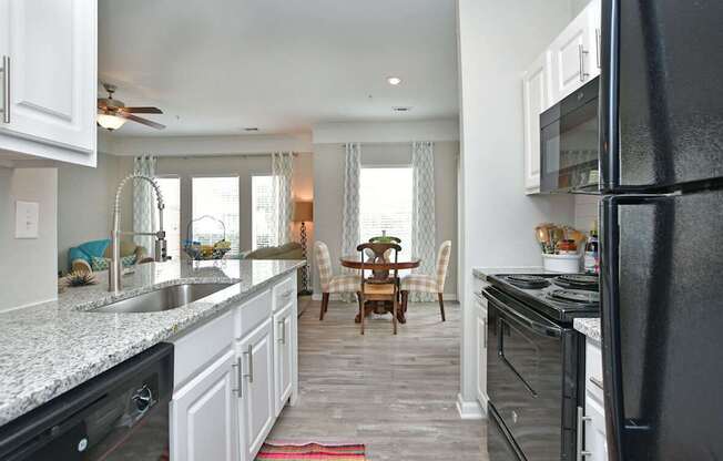 A kitchen with white cabinets and black appliances.at Braxton Woods Lake, Greenville, SC 29607