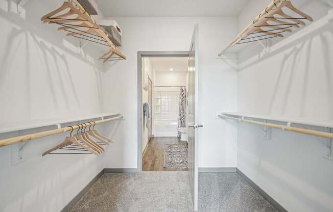 a walk in closet with wooden racks and a mirror at The Quarry Luxury Apartment Homes, Colorado