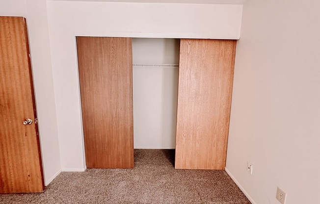 an empty closet in a room with wood doors