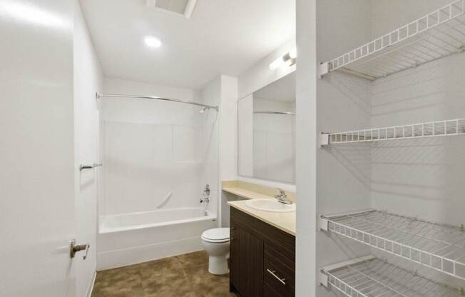 A white bathroom with a walk in shower and a toilet.