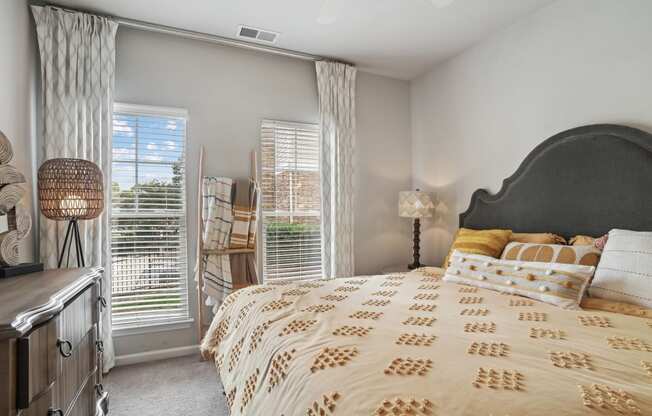 a bedroom with a large bed and two windows