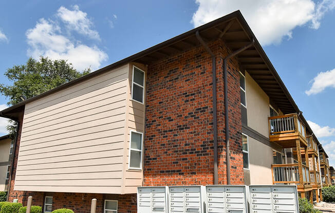 the front of a house with a brick wall and a staircase