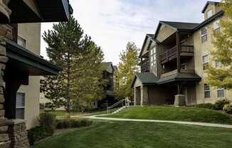 A large apartment complex with a green lawn in front.