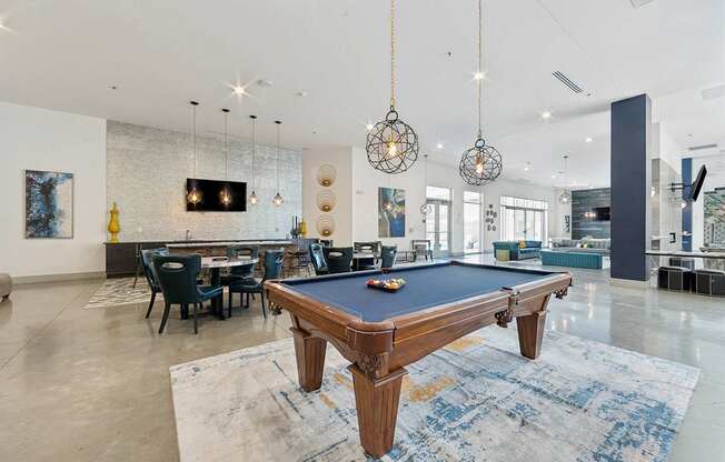 A pool table is in the middle of a room with a blue rug.